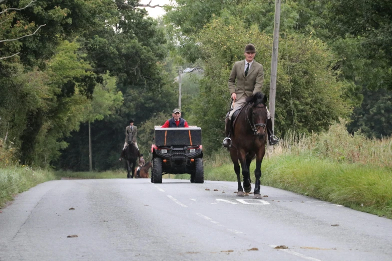 a couple riding horses while a jeep passes