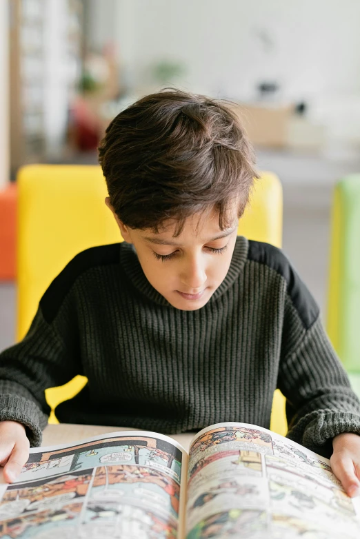 a  sitting at a table while reading