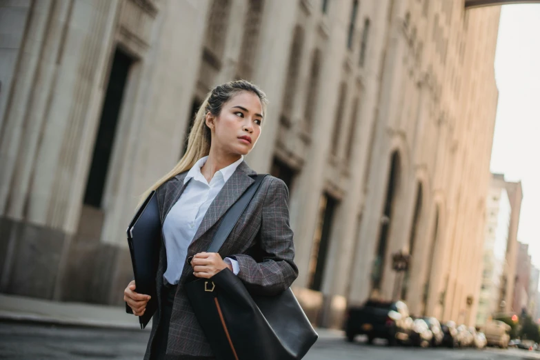 woman wearing black suit and holding a briefcase in her hands