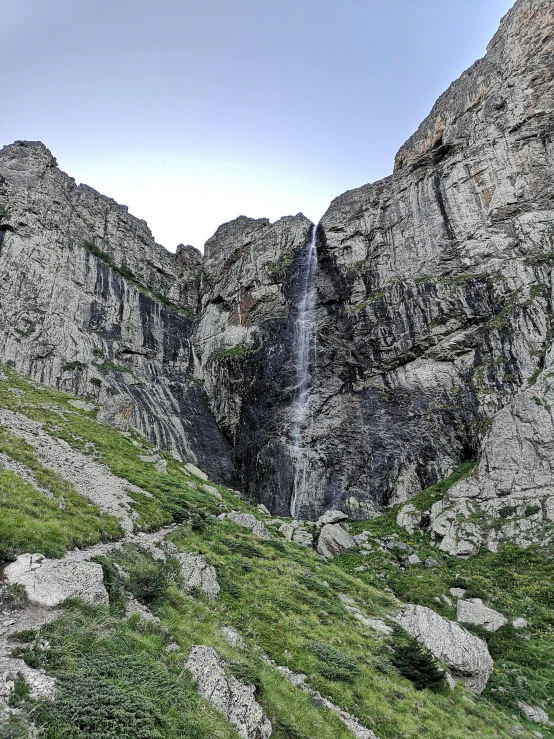 the waterfall at the foot of a mountain is high in the sky