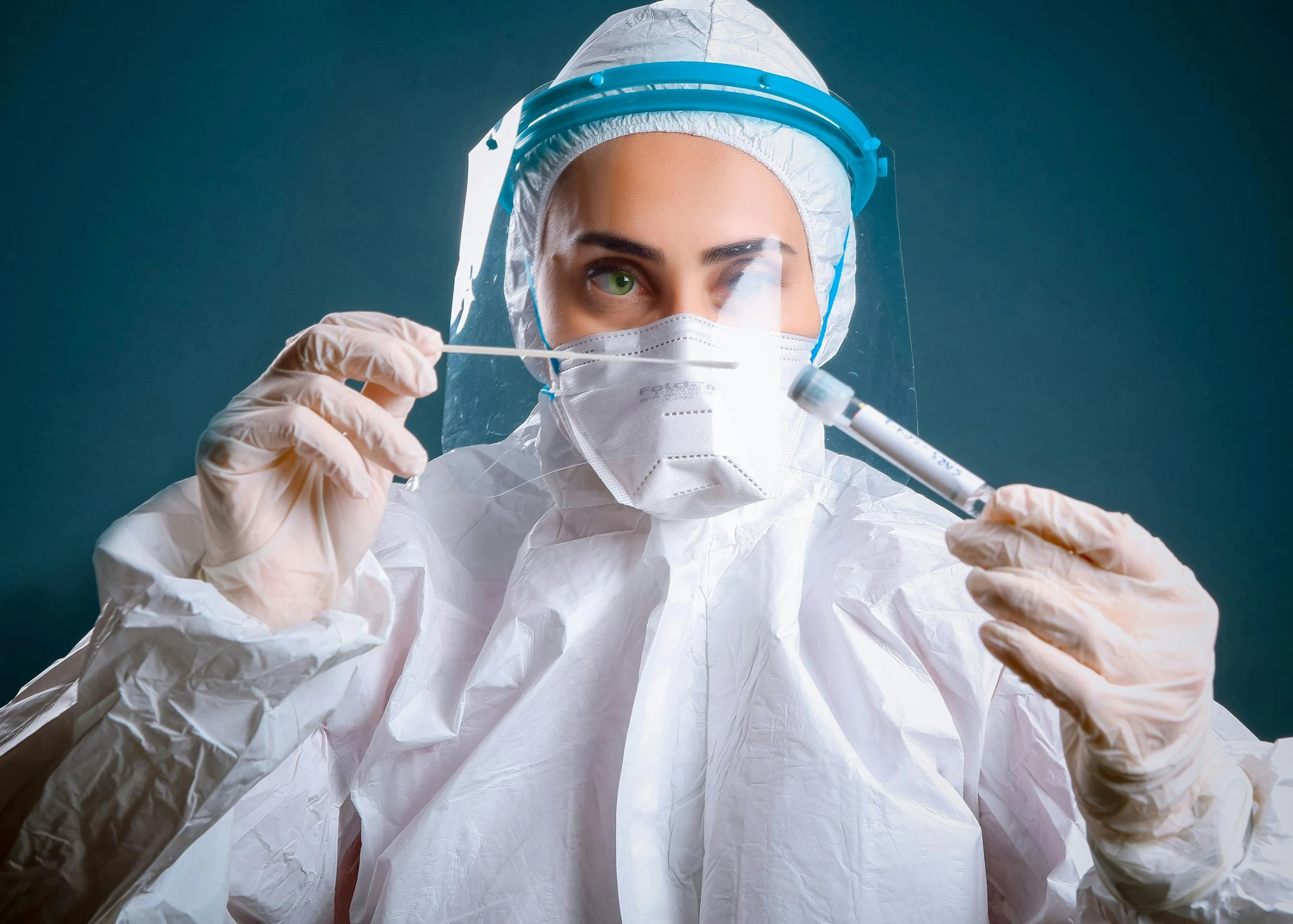 a woman is wearing medical garb and holding scissors in her hands