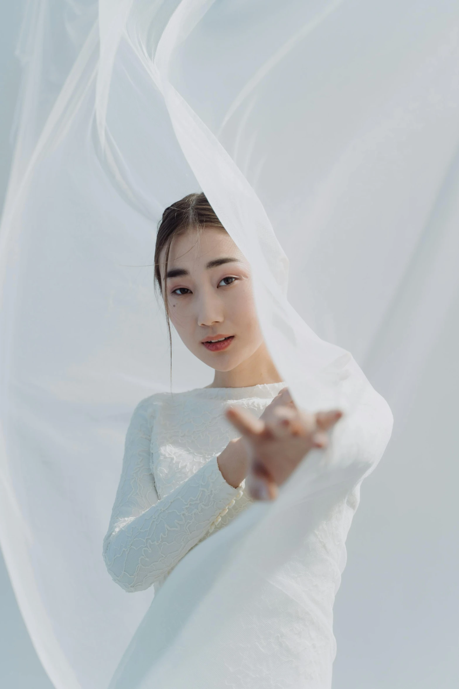 a woman wearing a long white dress is touching her finger