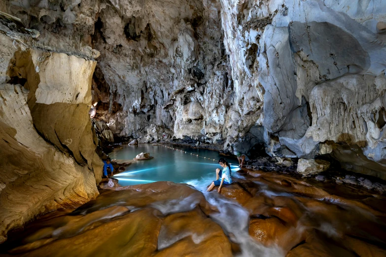 a group of people are standing in a cave