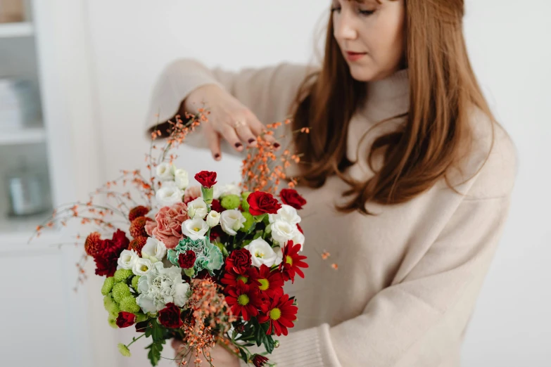 a young woman is holding a bunch of flowers