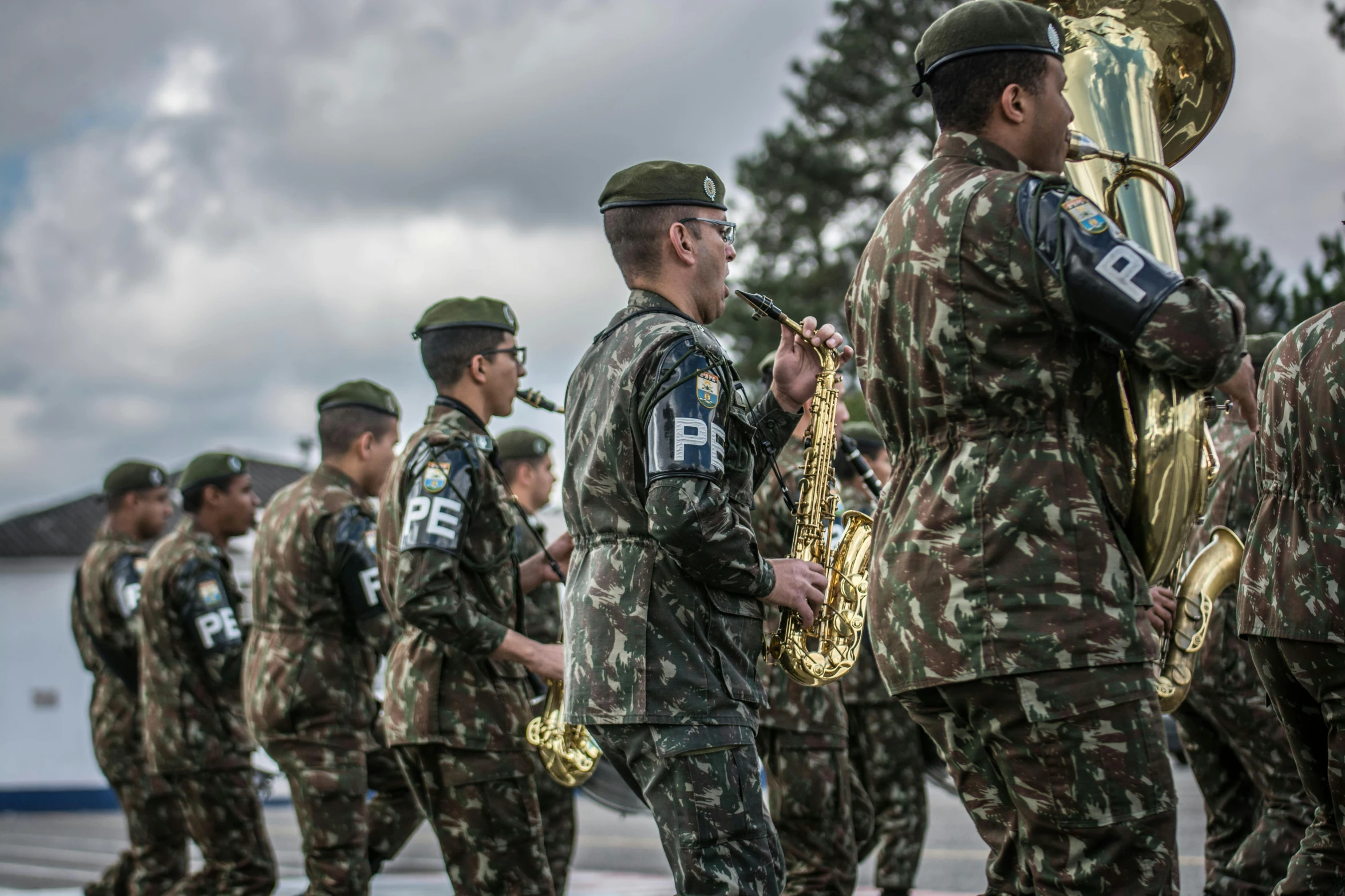 many soldiers are standing outside near a tree and some trees