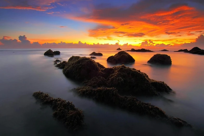 beautiful sunrise with a number of rocks in the water