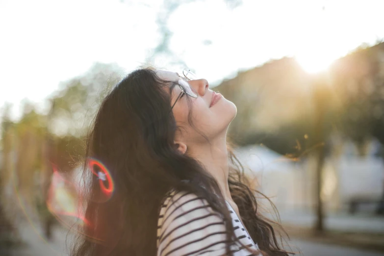 a woman looks up into the sky and smiles