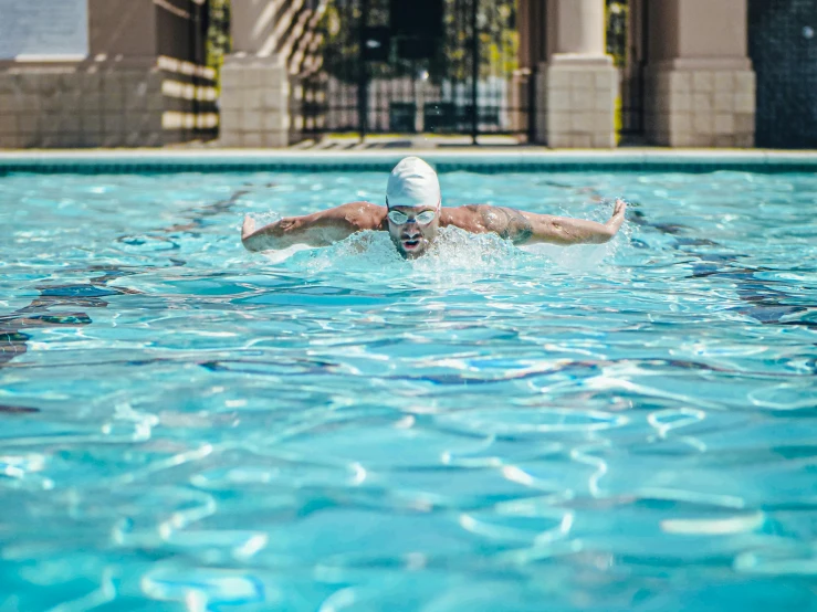 a man swimming in a pool during the day