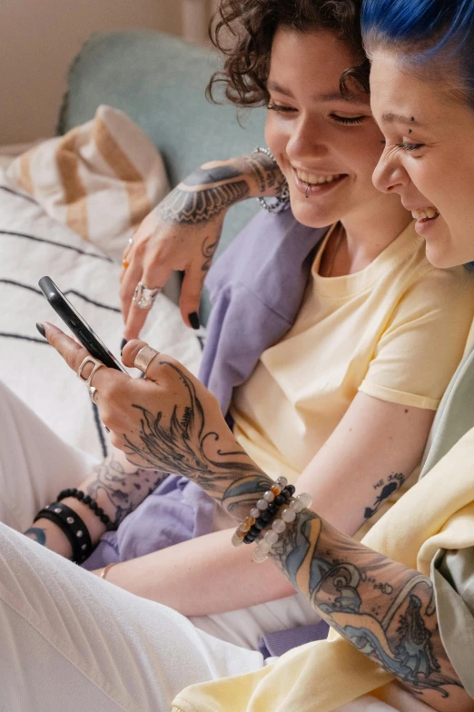 two women sitting on a bed next to each other