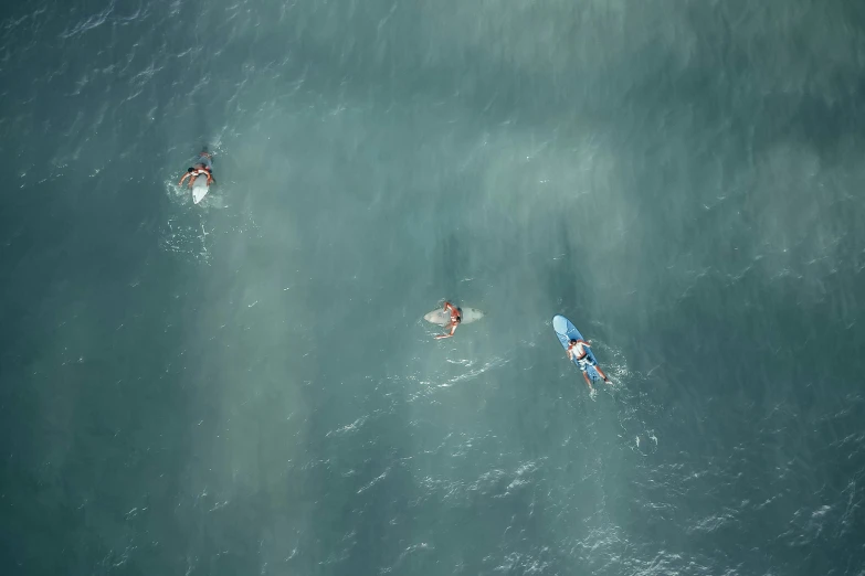 three surfers riding the ocean on their boards