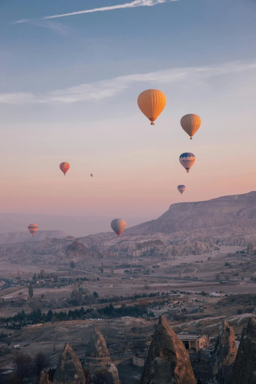 several  air balloons flying over the valley