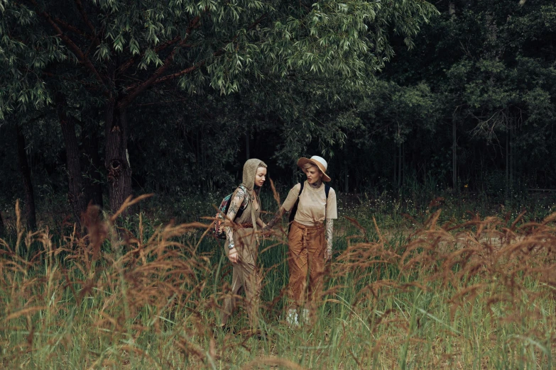 the two girls are walking through the woods together