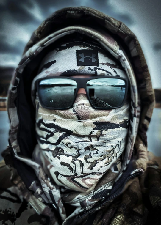 a person with large sunglasses and a hooded jacket