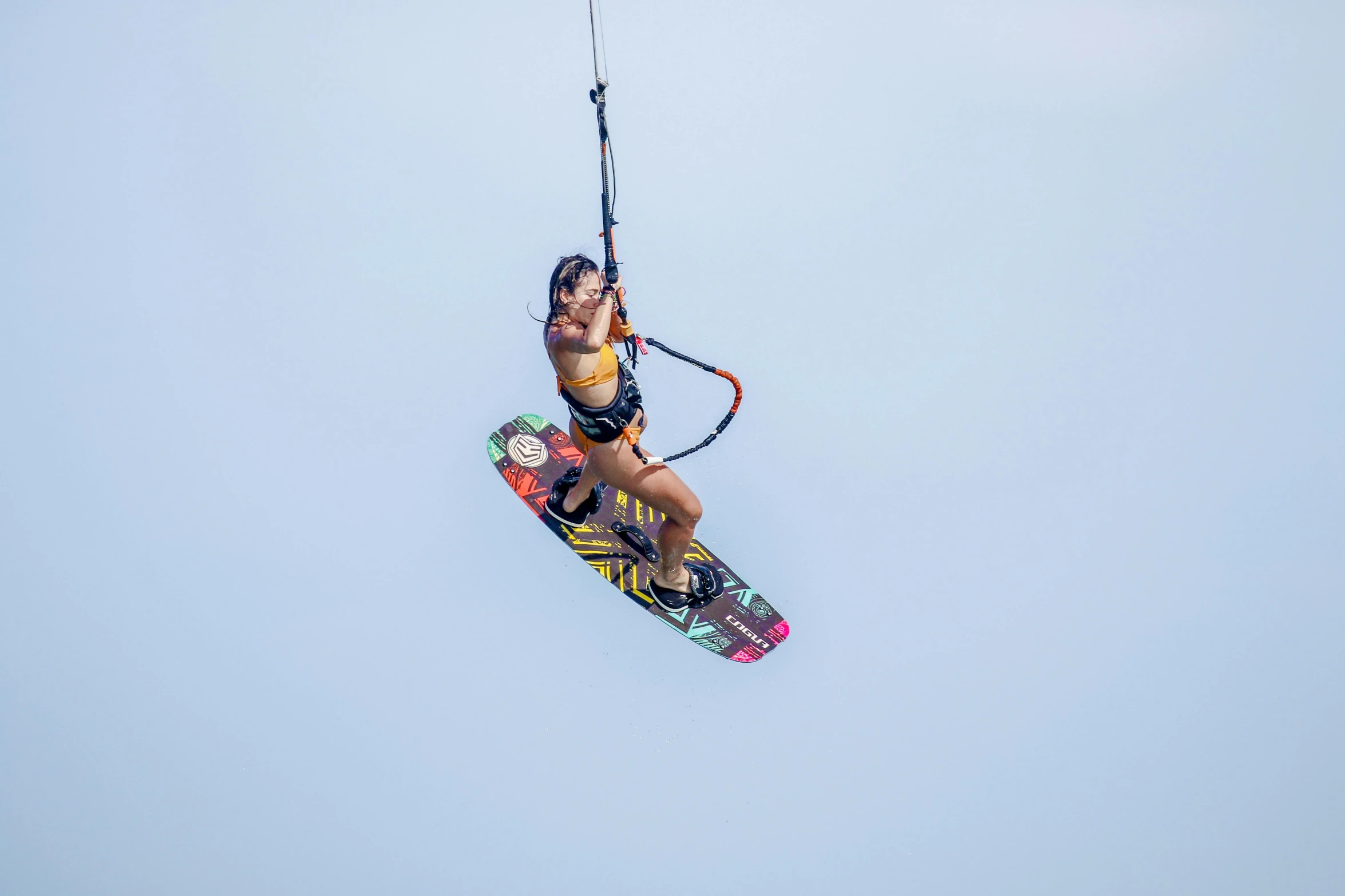 a woman flying through the air while riding a kite board