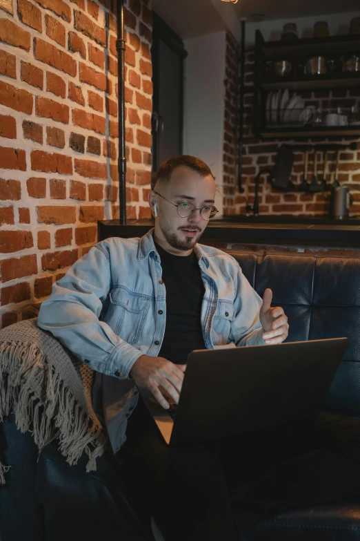 a man in a denim jacket is sitting on a sofa