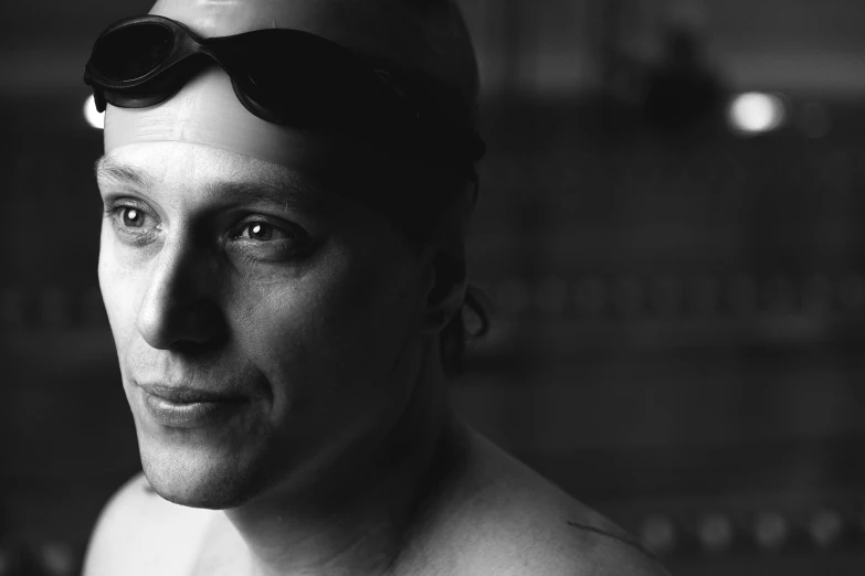 black and white image of a man with swimming goggles