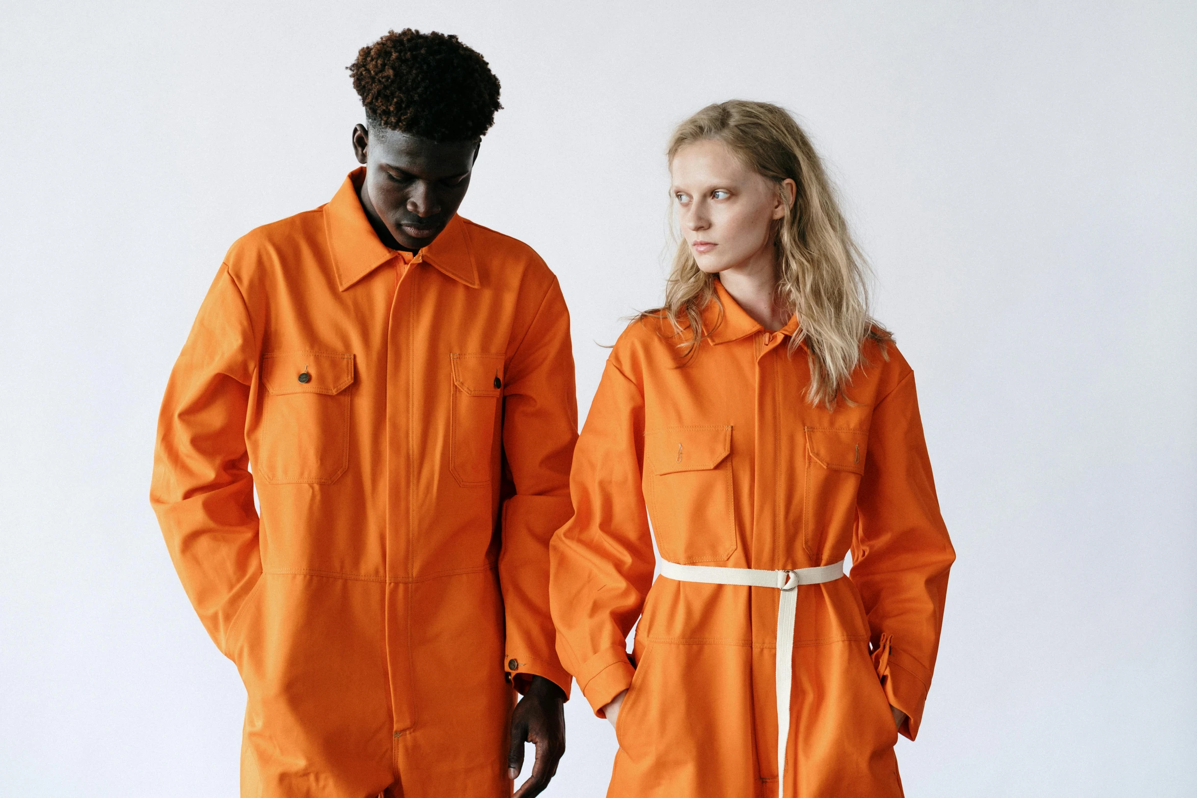 two people in orange clothing are facing each other