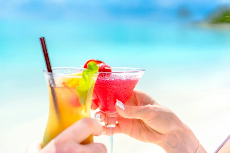 people holding cocktail glasses in their hands and drinking from the inside out of them