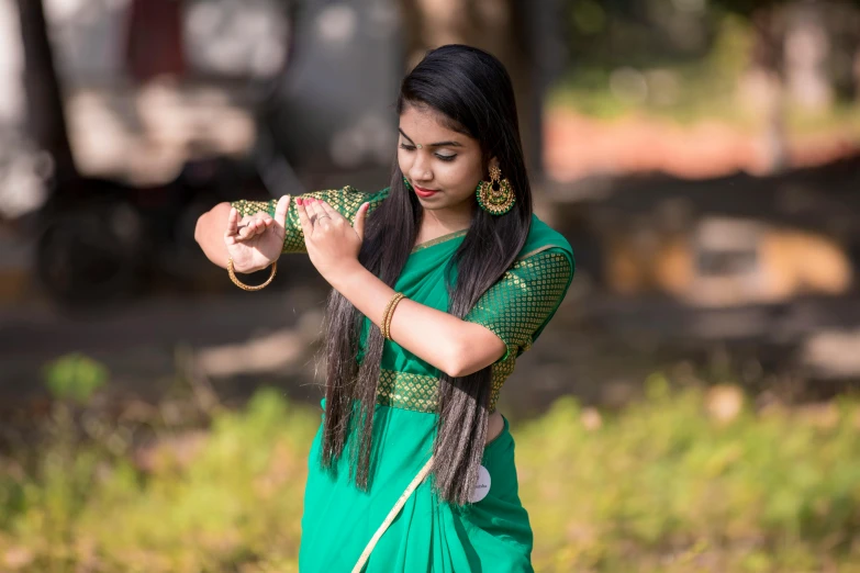 woman wearing long green sari with ethnic necklaces