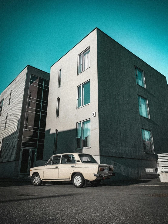 two cars are parked in front of a tall building