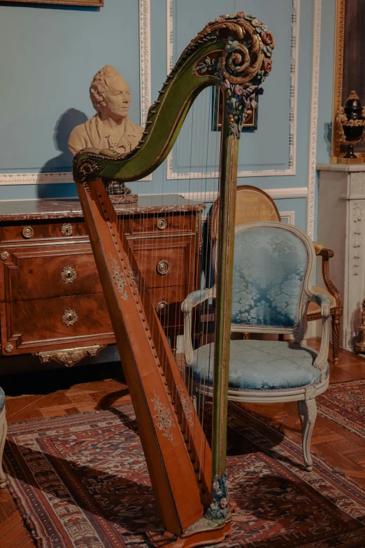 a tall harp with a wood pole in front of a wooden cabinet