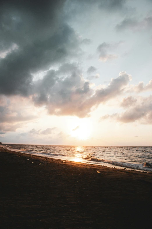 a man walking a dog down a beach near the ocean