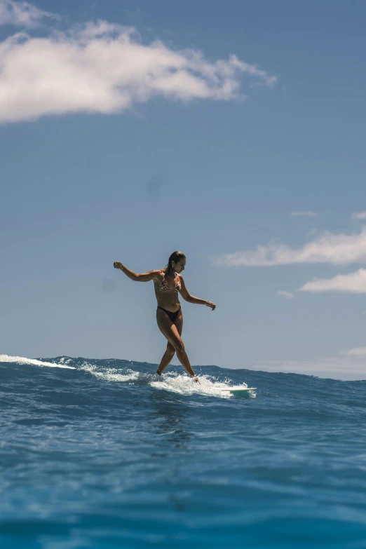 a woman wearing a bikini on a surfboard