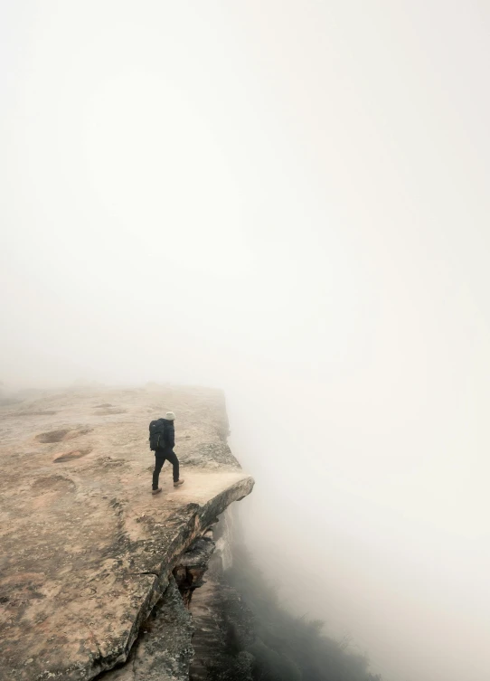 a person with a backpack walking in the middle of the mountain