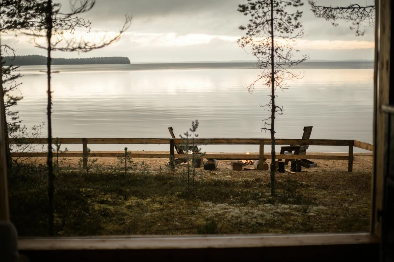 a bench on the side of a lake near the trees