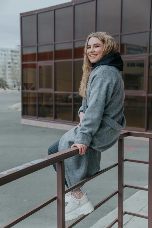 a woman standing on a railing with her leg crossed