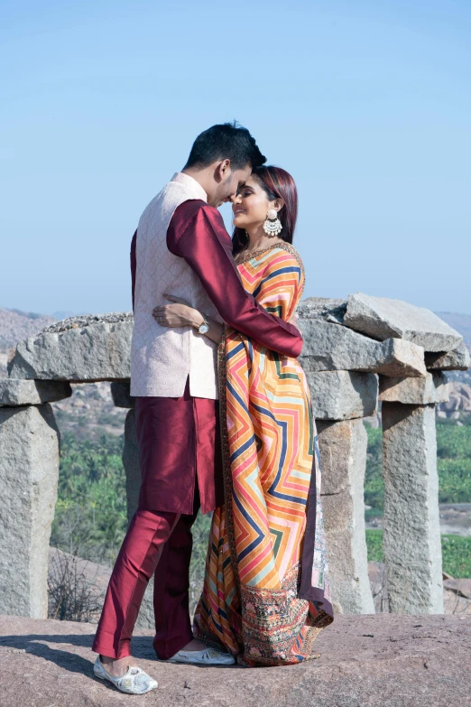 an asian couple emcing at the top of a mountain