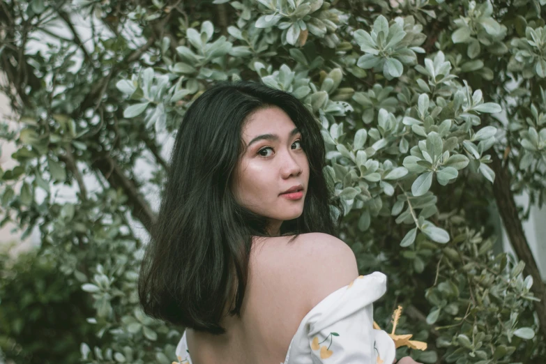 an attractive young lady with long dark hair and white dress