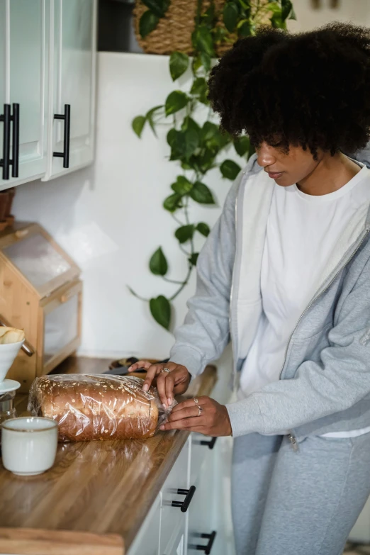 a black woman in a kitchen cuts up a carrot