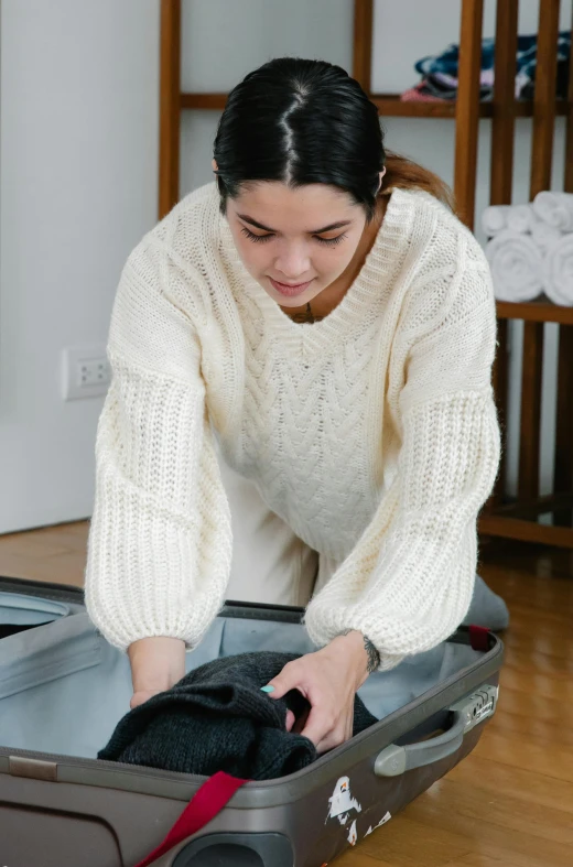 a woman puts her clothes in a suitcase