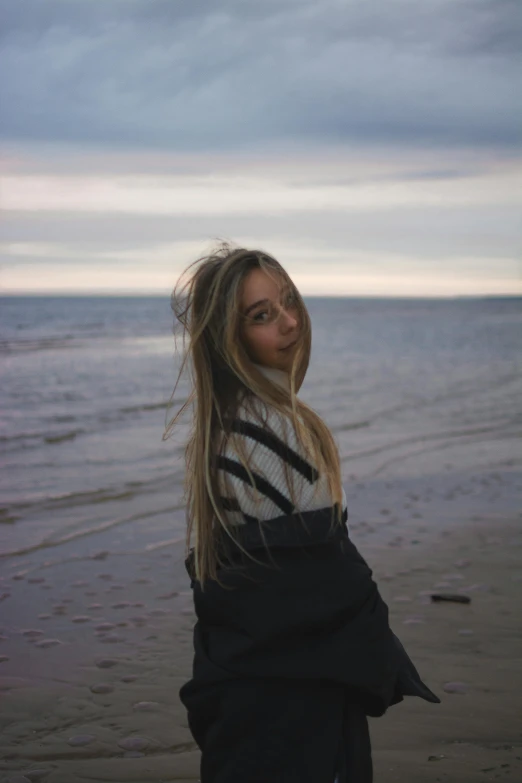 the woman is smiling as she stands on the beach