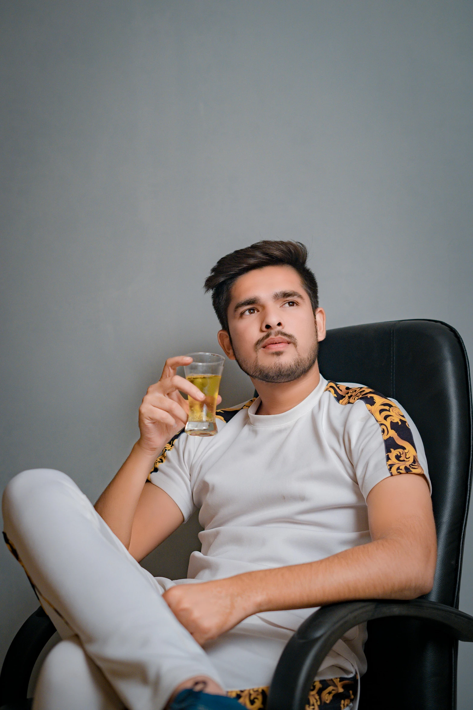 a man sitting in a chair with his hand on the glass