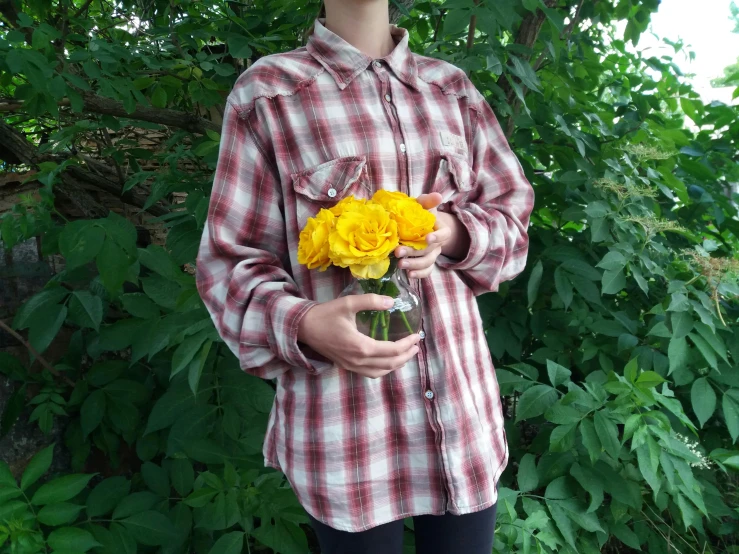 a person in glasses standing next to some bushes