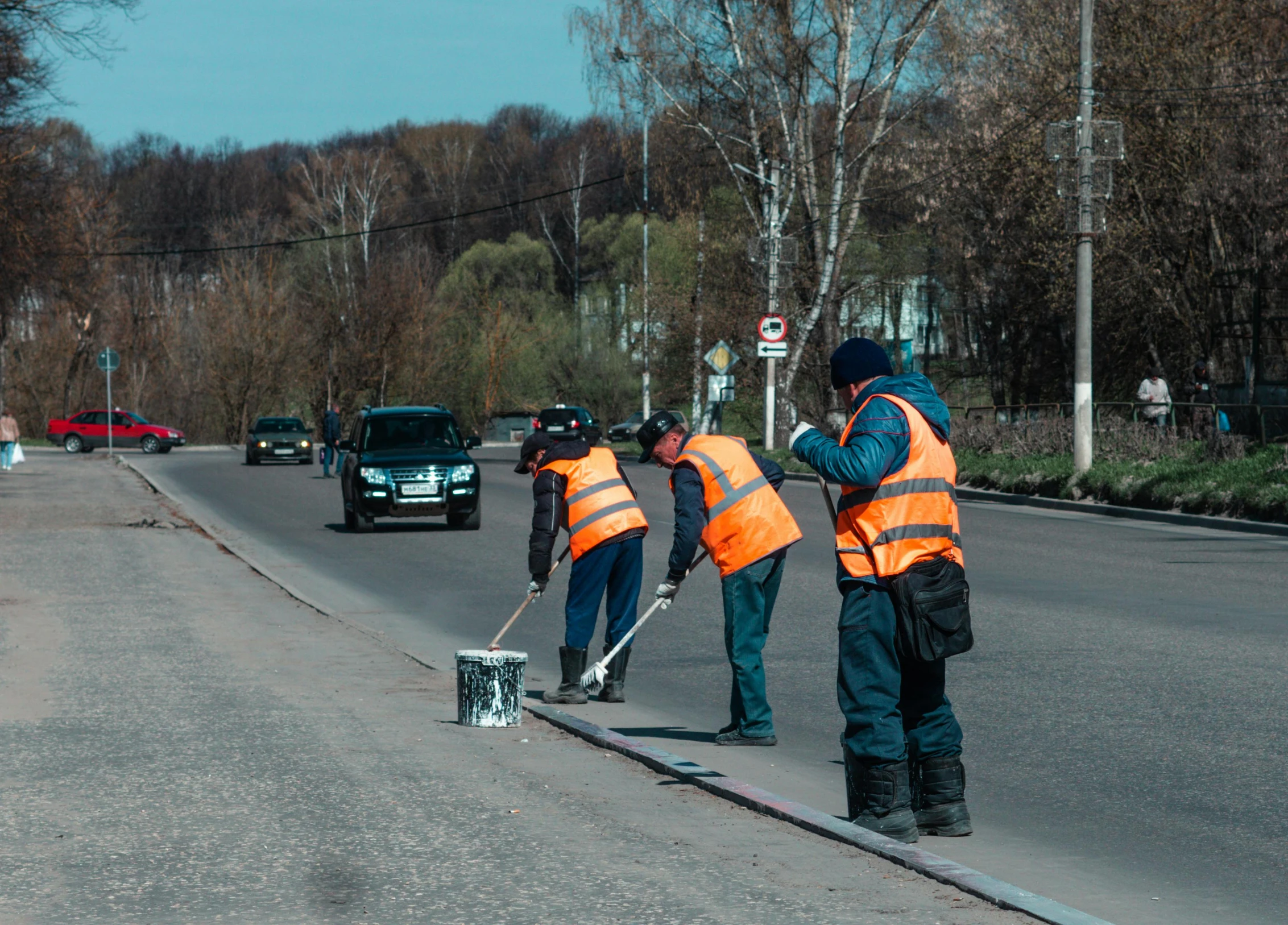 the workers are in orange vests working on the street