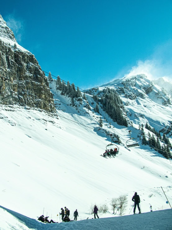 a group of skiers on a steep snowy mountain