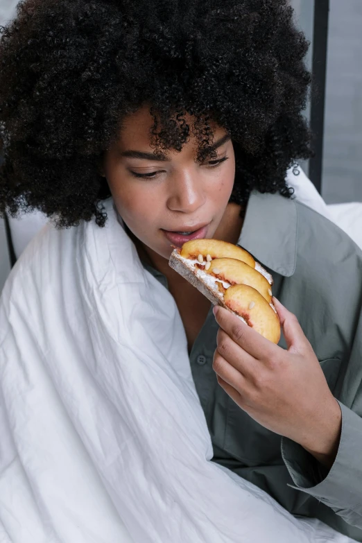 a woman with afro is eating a sandwich