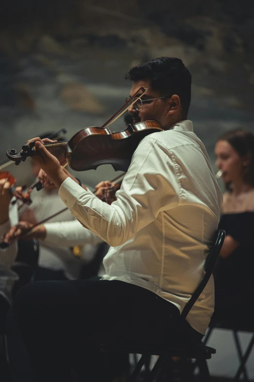 the man is playing the violin with his other hands