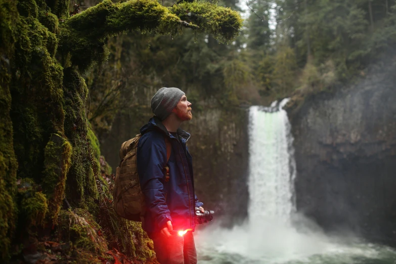 a man is standing next to a waterfall