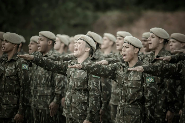 a large group of men in army uniforms, some with their hands out