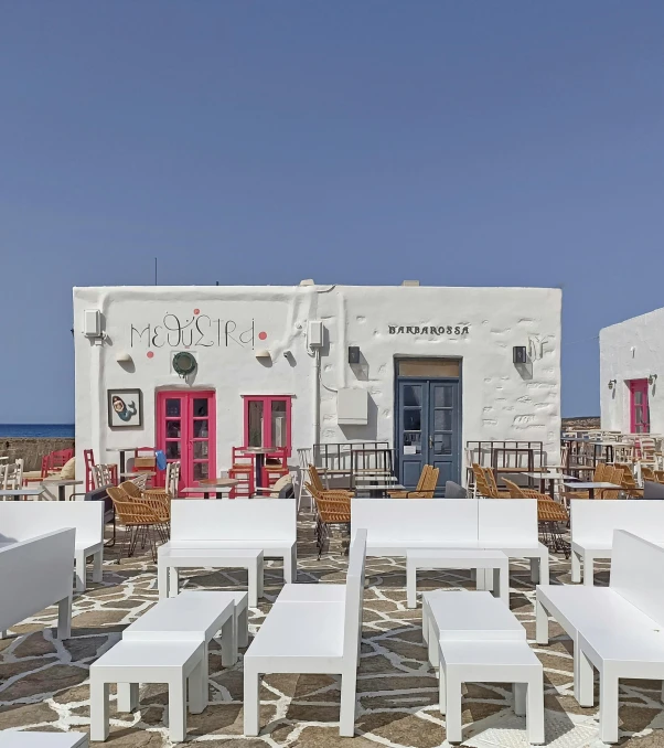 there are many tables and chairs that are on the sand