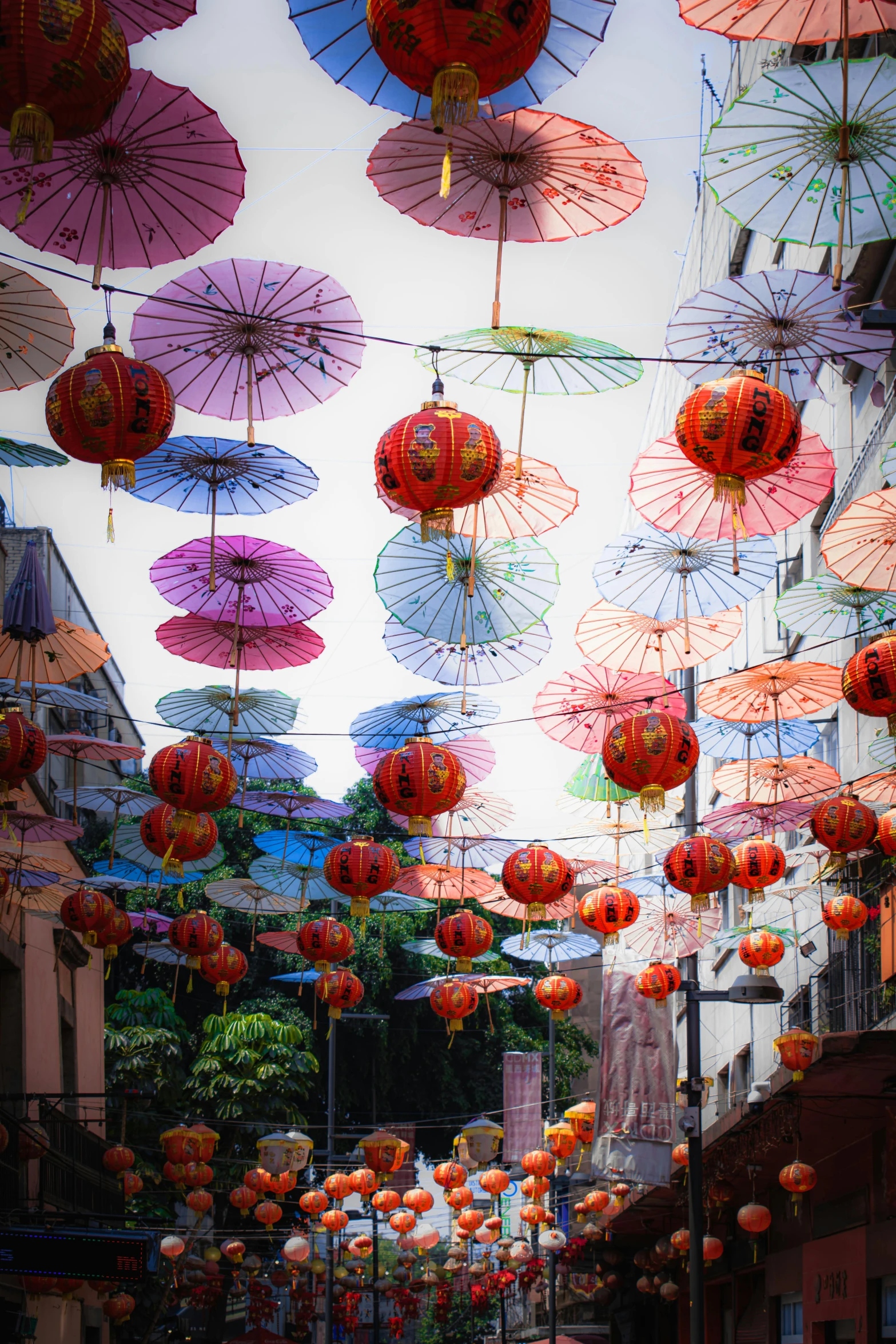 umbrellas hung from a line over a city street