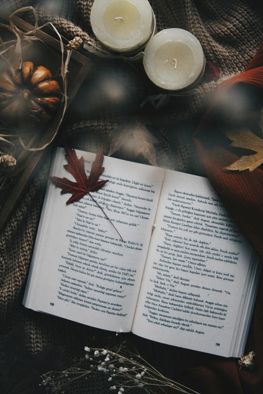 two candles and an open book sitting on a table