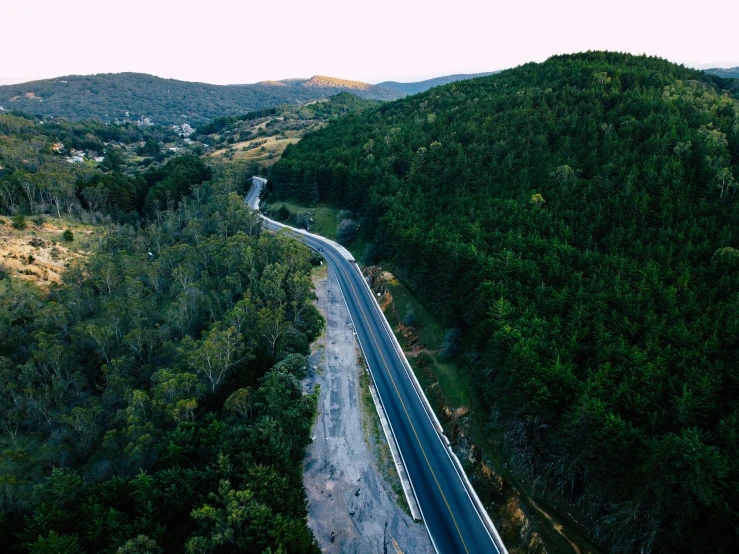 a highway with a truck is winding up a hill in the background