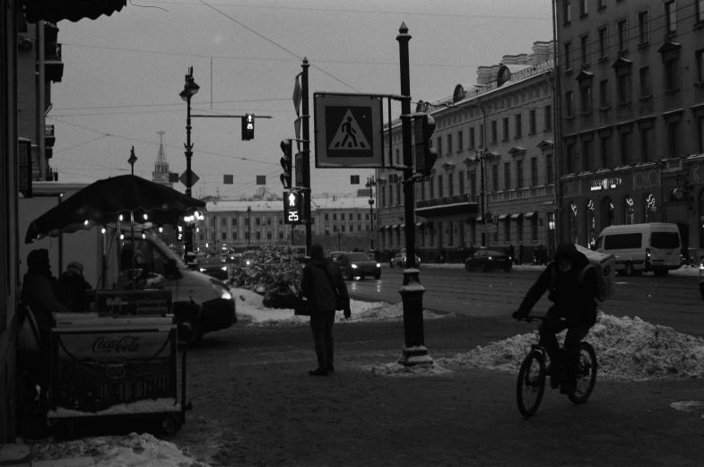 two men ride their bikes down a city street