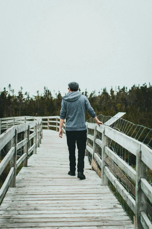 the person is walking up the wooden walkway