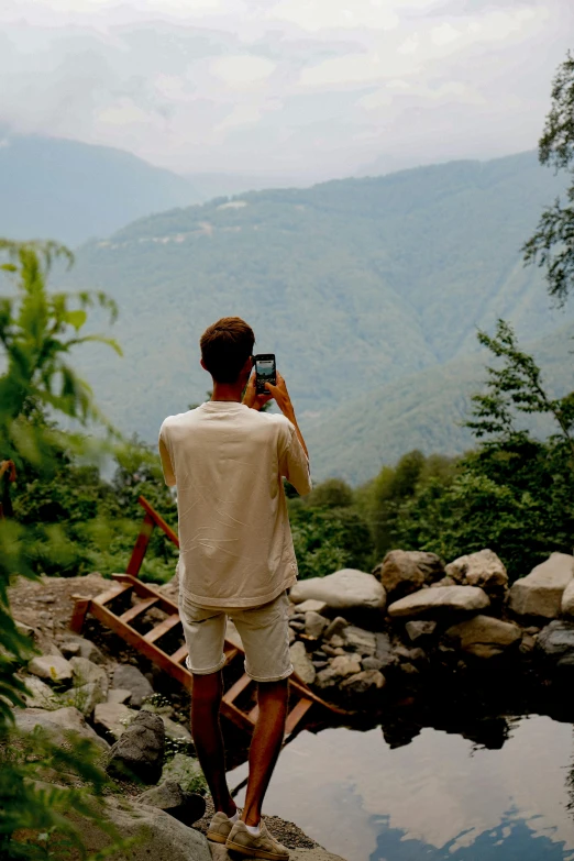 a man taking a po with his phone in the woods